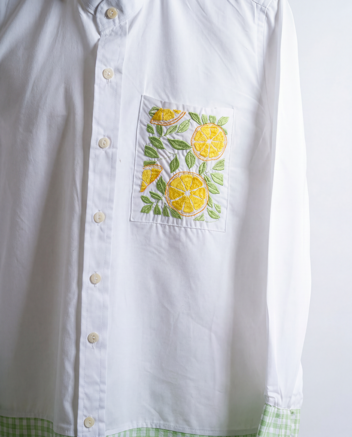 White shirt with lemon and leaf design on a white background