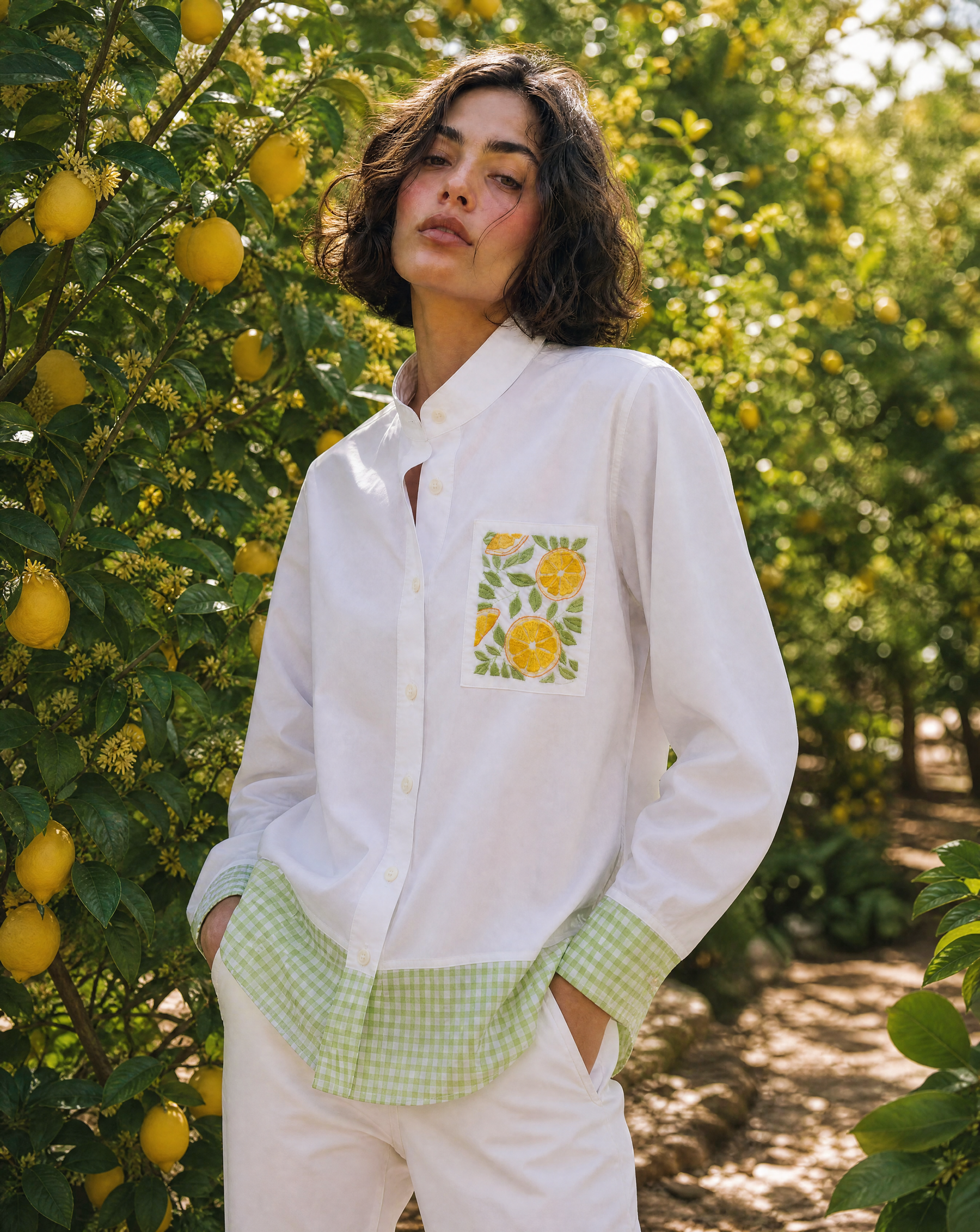 Woman wearing a white shirt with a lemon design in an orchard